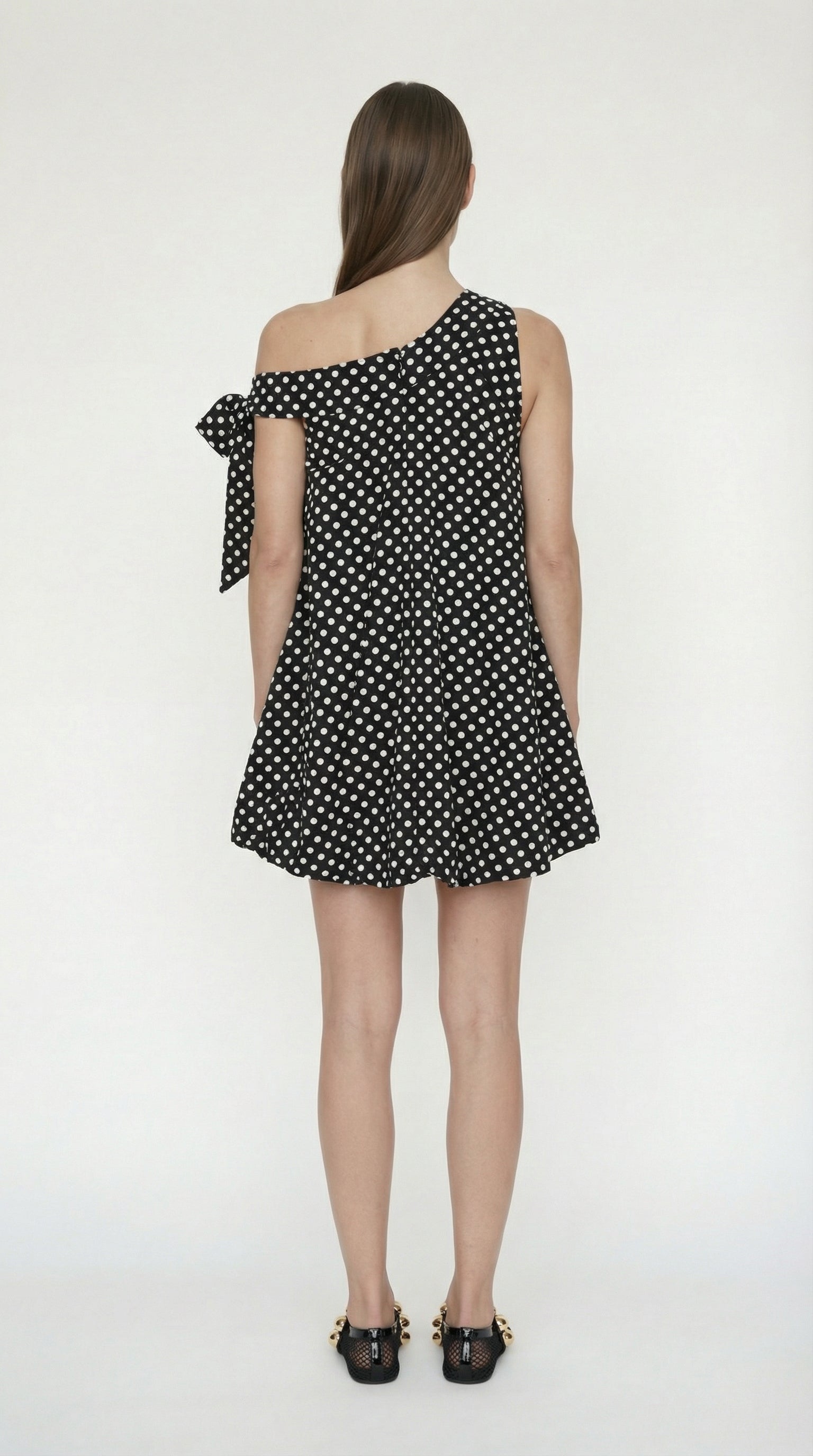 Back view of the Bow Bubble dress showing the invisible zipper and the seamless transition of the polka dot print.