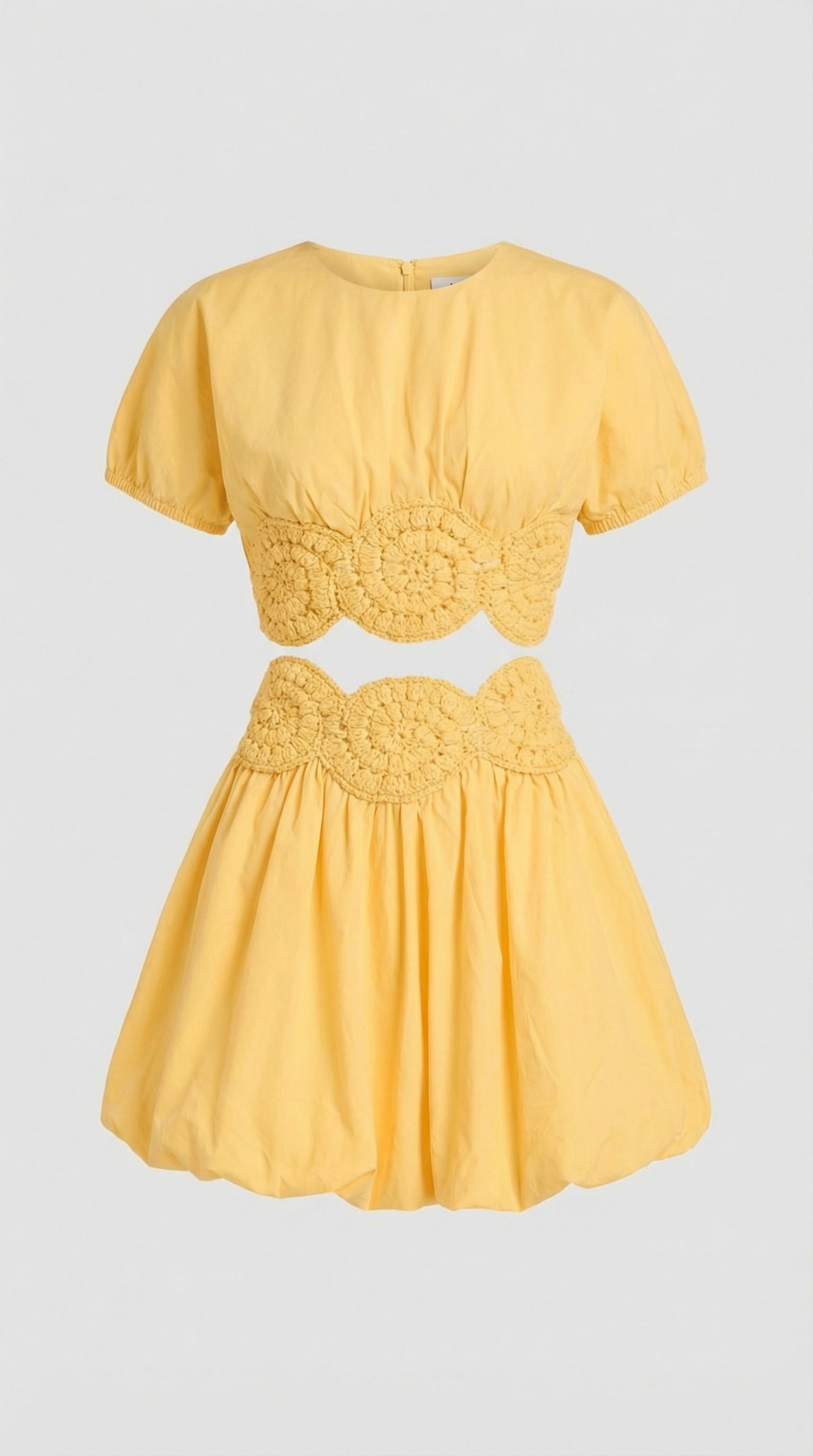 Macro shot of the elexiay handmade white crochet trim and cutout details at the waist of the yellow Amara crop top.