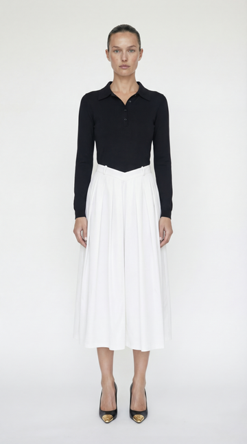 Front view of the Elexiay Sonia Dress featuring a black knit polo bodice and a high-contrast white pleated midi skirt