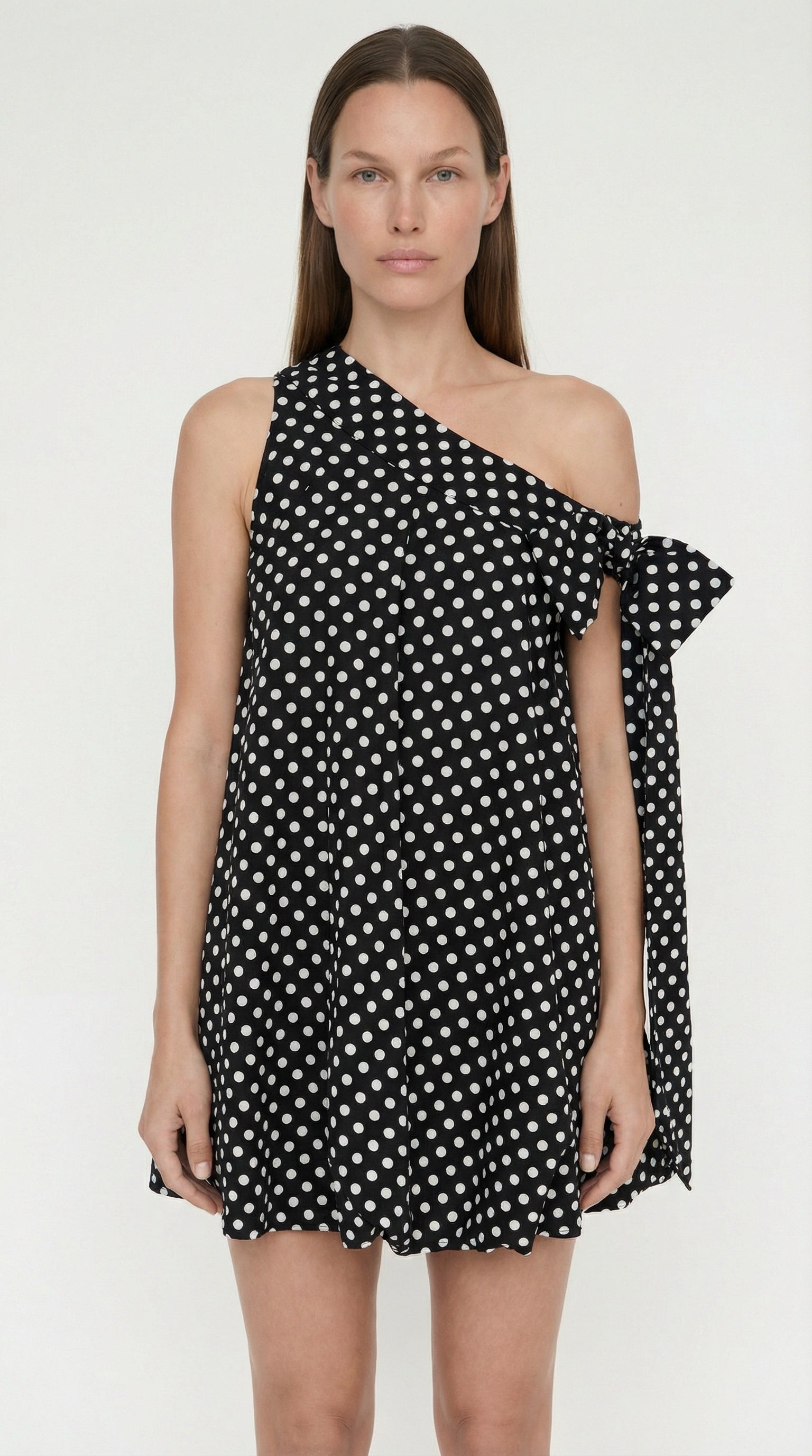 Close-up of the oversized white sculptural bows on the shoulders of the Elexiay Bow Bubble dress, contrasting with the black polka dot bodice.